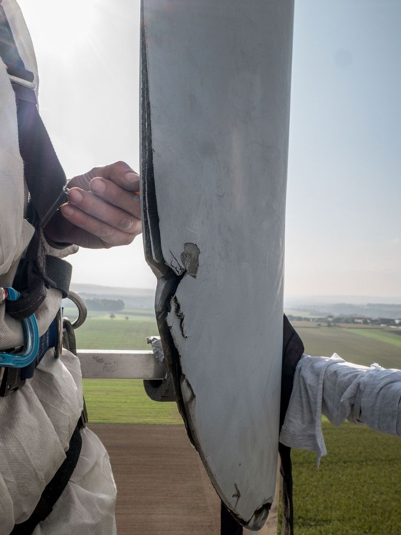 Ein Mann begutachtet ein Rotorblatt.