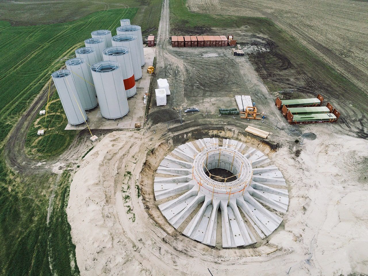 Luftaufnahme eines großen Zementbehälters, der in einer industriellen Umgebung steht, umgeben von weiteren Anlagen.