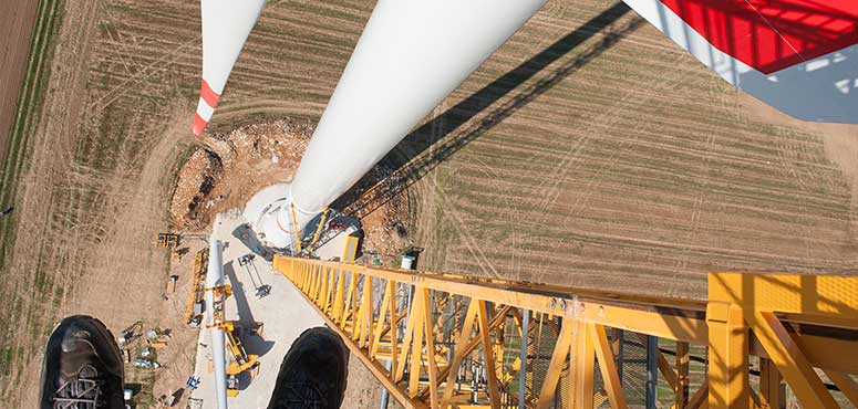 Eine Windkraftanlage wird auf einem Feld errichtet, um erneuerbare Energie zu fördern und die Umwelt zu schützen.