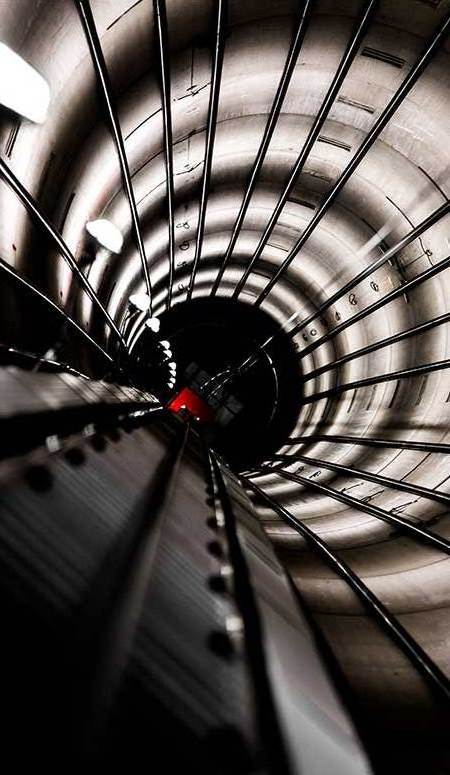 Schwarz-weiß-Foto eines Tunnels, der in die Dunkelheit führt, mit klaren Linien und einer geheimnisvollen Atmosphäre.